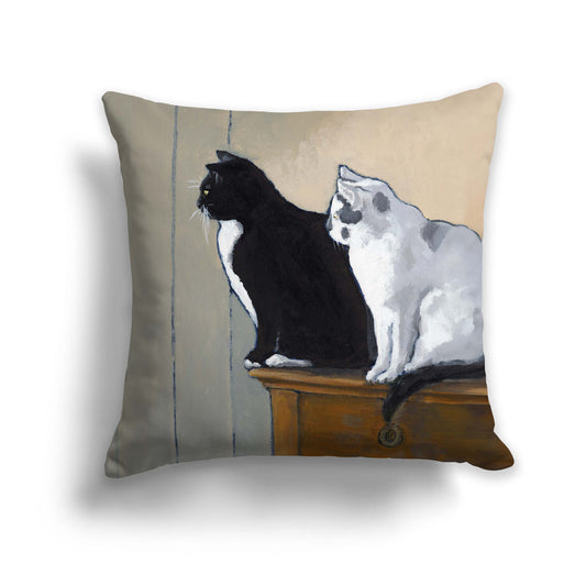 A square throw pillow featuring a printed artwork of two cats, one black and one white, sitting on a surface.