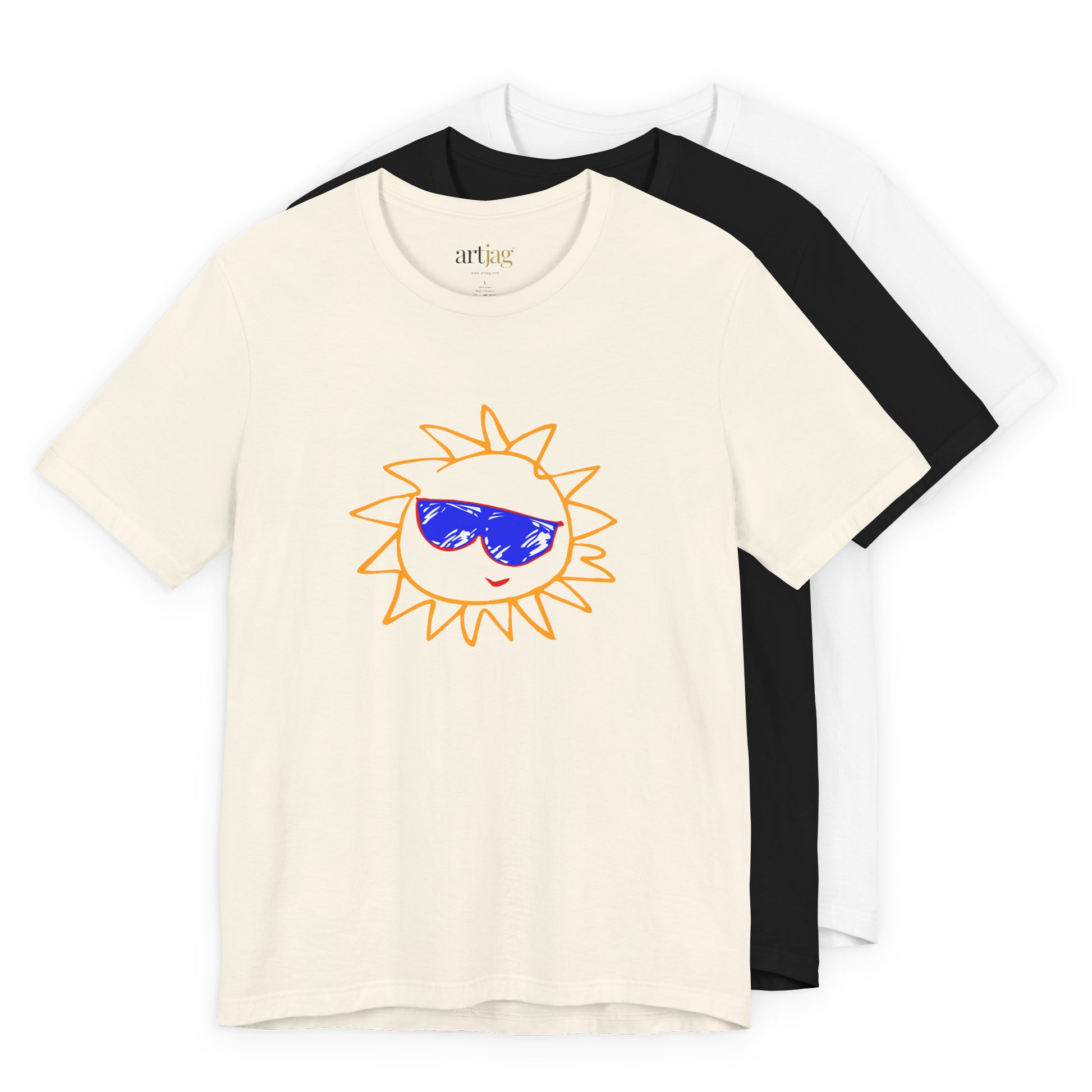 Three short-sleeve crewneck t-shirts layered together on a white background: a cream shirt in front with a sun graphic wearing blue sunglasses, a black shirt in the middle, and a white shirt in the back. The inner neck label reads 'artjag'.