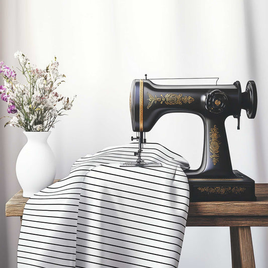 White Spun Polyester Fabric with Fine Black Stripes, FASP-1010-151, on an antique sewing machine sitting on a desk with vase of beautiful flowers.