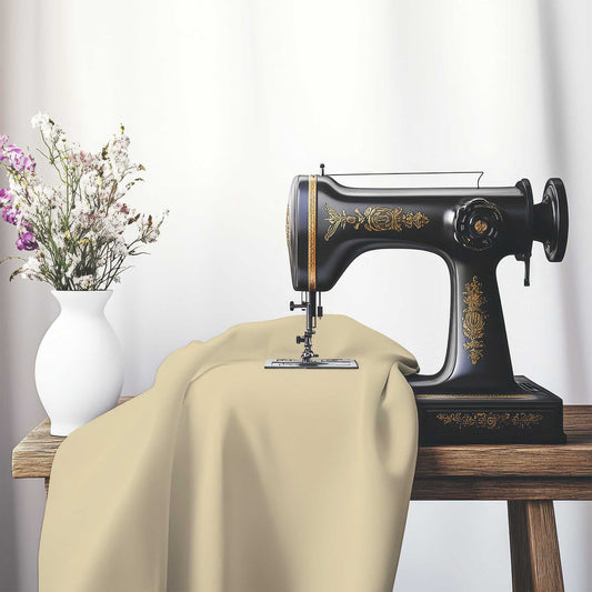Tan Spun Polyester Fabric, FASP-1014-999, on an antique sewing machine sitting on a desk with vase of beautiful flowers.