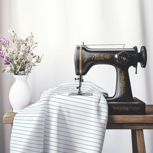 White Spun Polyester Fabric with Fine Blue Stripes, FASP-1231-151, on an antique sewing machine sitting on a desk with vase of beautiful flowers.