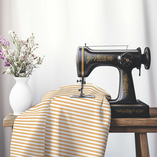 White Spun Polyester Fabric with Thin Orange Bars, FASP-1232-241, on an antique sewing machine sitting on a desk with vase of beautiful flowers.