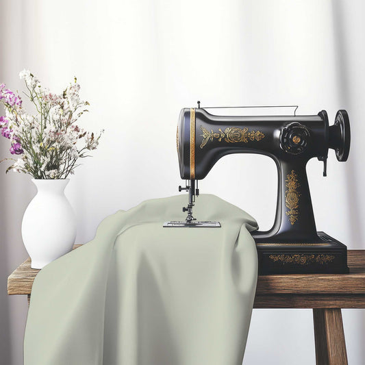 Pale Green Spun Polyester Fabric, FASP-1241-999, on an antique sewing machine sitting on a desk with vase of beautiful flowers.