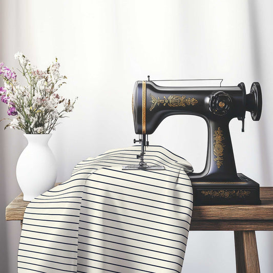 Spun Polyester Fabric with Fine Navy Blue Stripes on Pale Cream, FASP-1273-151, on an antique sewing machine sitting on a desk with vase of beautiful flowers.