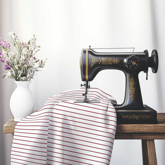 White Spun Polyester Fabric with Fine Burgundy Red Stripes, FASP-1281-151, on an antique sewing machine sitting on a desk with vase of beautiful flowers.