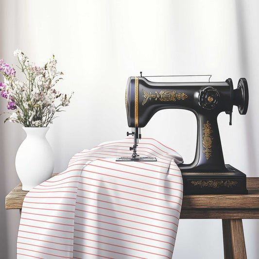 White Spun Polyester Fabric with Fine Pink Stripes, FASP-1340-151, on an antique sewing machine sitting on a desk with vase of beautiful flowers.