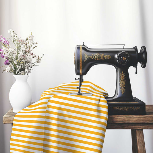 White Spun Polyester Fabric with Yellow-Orange Bars, FASP-1390-051, on an antique sewing machine sitting on a desk with vase of beautiful flowers.