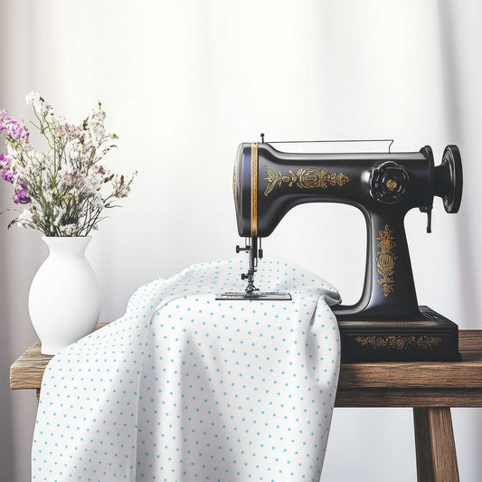 White Spun Polyester Fabric with Fine Blue Diamonds, FASP-1430-111, on an antique sewing machine sitting on a desk with vase of beautiful flowers.