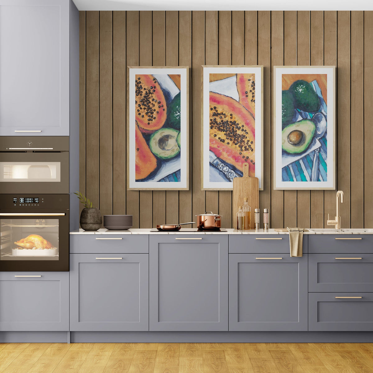 Papaya & Avocado Fine Art Print Triptych | Styled in Sleek Modern Kitchen with Slate Blue Shaker Cabinets, Warm Oak Slat Feature Wall, Marble Countertop and Copper Cookware