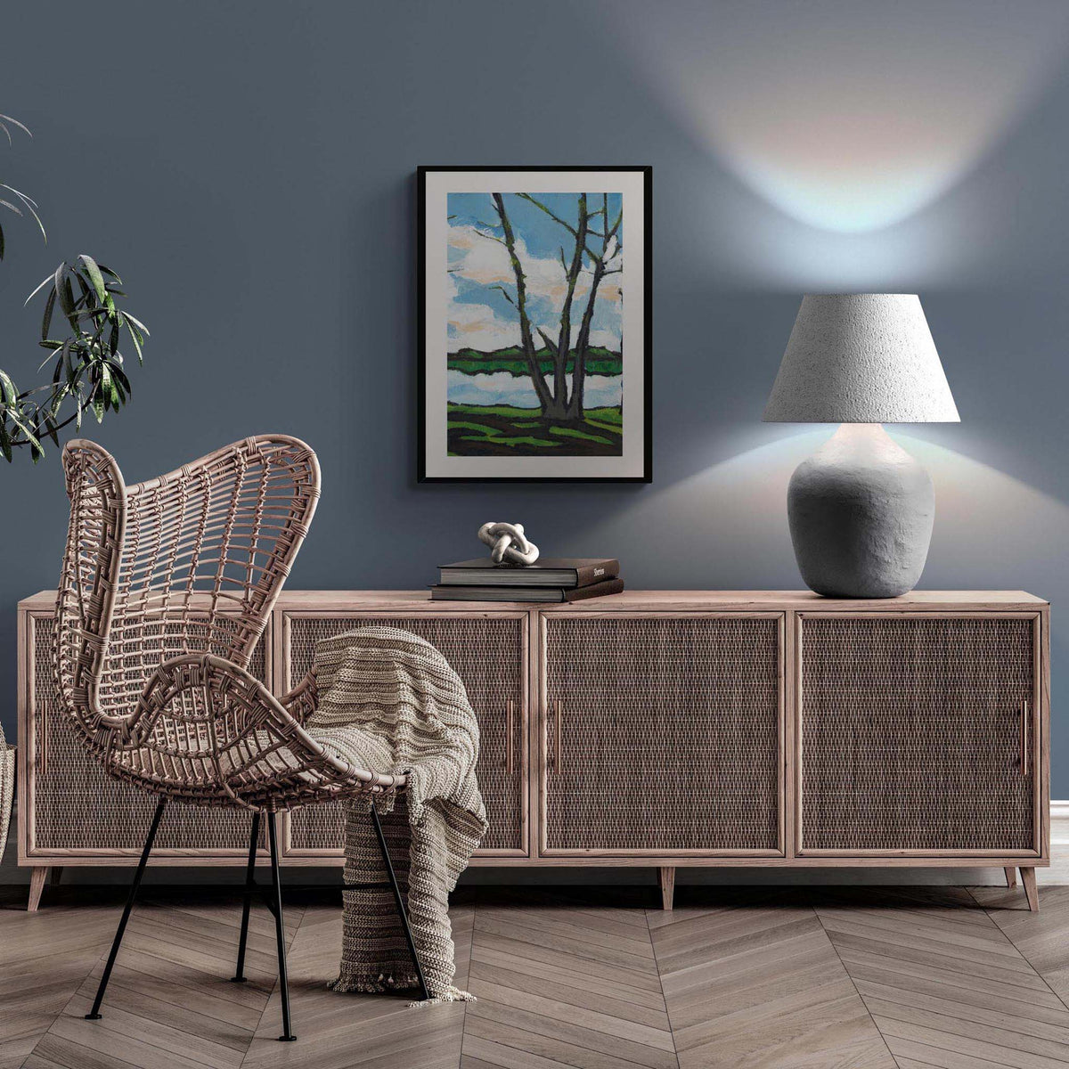Lakeshore Landscape Fine Art Print | Styled in Moody Steel-Blue Living Room with Wide Rattan Cane Credenza, Sculptural Stone Table Lamp, Woven Rattan Wingback Chair and Herringbone Parquet Floor